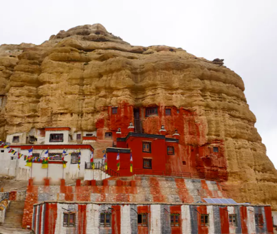 Red grey cliff with monastery in Chhoser village of Upper Mustang