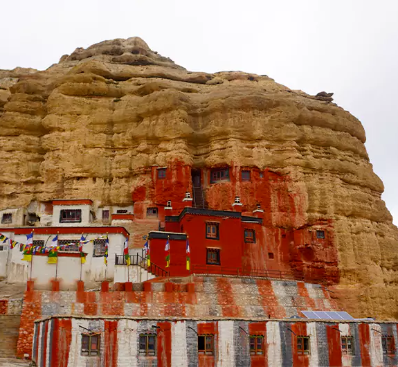 Red grey cliff with monastery in Chhoser village of Upper Mustang