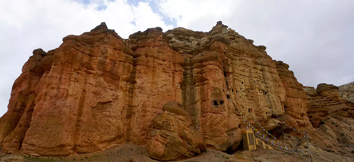 Chhoser cave, carved on the big red cliff, can be seen during the Upper Mustang Trek